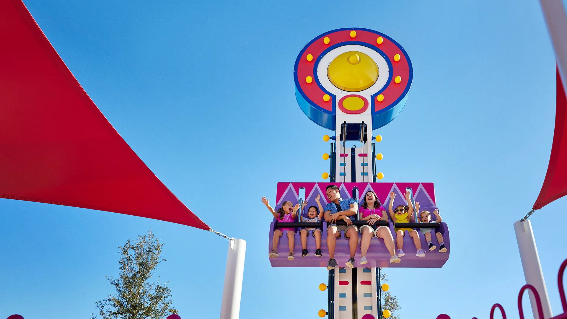 Niños y padres disfrutan del paseo Mr. Bull's High Striker en Peppa Pig Theme Park en Dallas Fort Worth. Las familias emocionadas son elevadas hacia arriba y hacia abajo en este divertido paseo, experimentando la diversión y emoción de esta atracción interactiva.